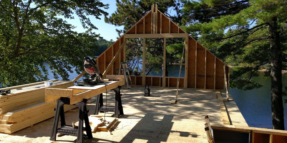 saw on the second floor with the widow openings  cut out but no roof yet with trees all around and a view of the lake in Camden, Maine new construction.