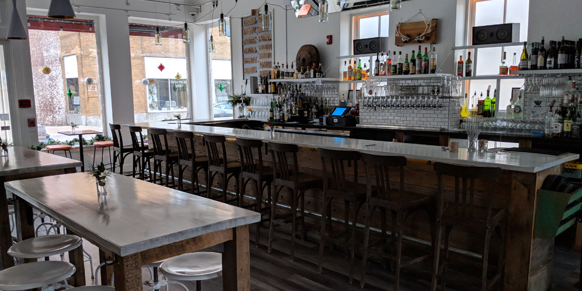 commercial remodel in rocklan maine of ada's kitchen with view of the bar, some tables and windows looking out onto main street in Rockland.